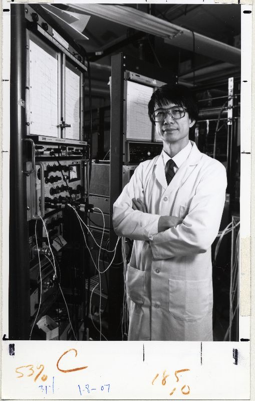 Paul Chu standing beside machines