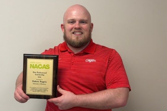 Dakota Rogers holding a NACAS South New Professional Scholarship award plaque