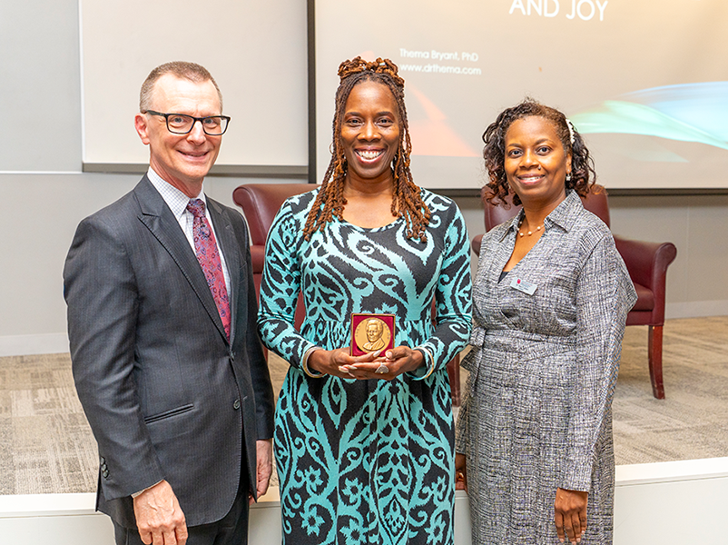 Dean Daniel O'Connor and Dr. Tara Green presenting Dr. Thema Bryant with the McGovern Medal of Service