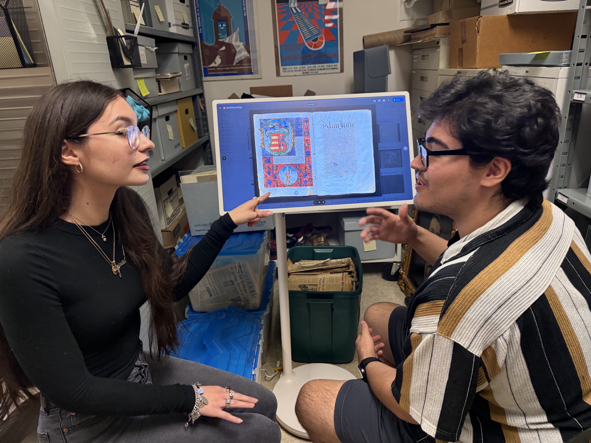 Scholars Isabela and Martin review digital records