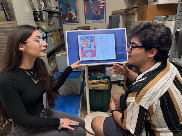 Scholars Isabela and Martin review digital records