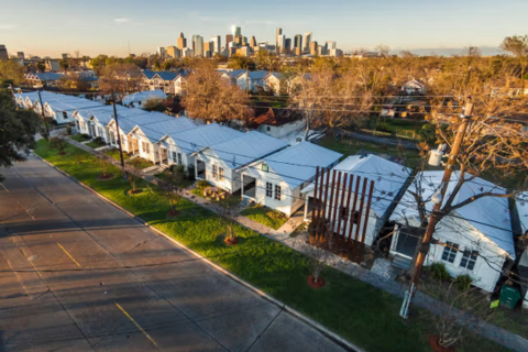 Row of homes in Houston’s historic Third Ward with the downtown skyline in the distance