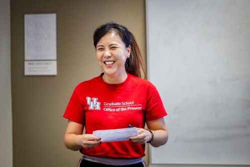 Female student smiling with a red shirt in class