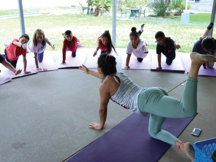 Yoga instructor teaching young kids