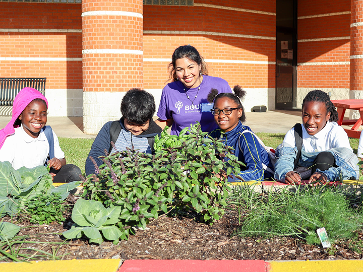 Intern with students outside with plants