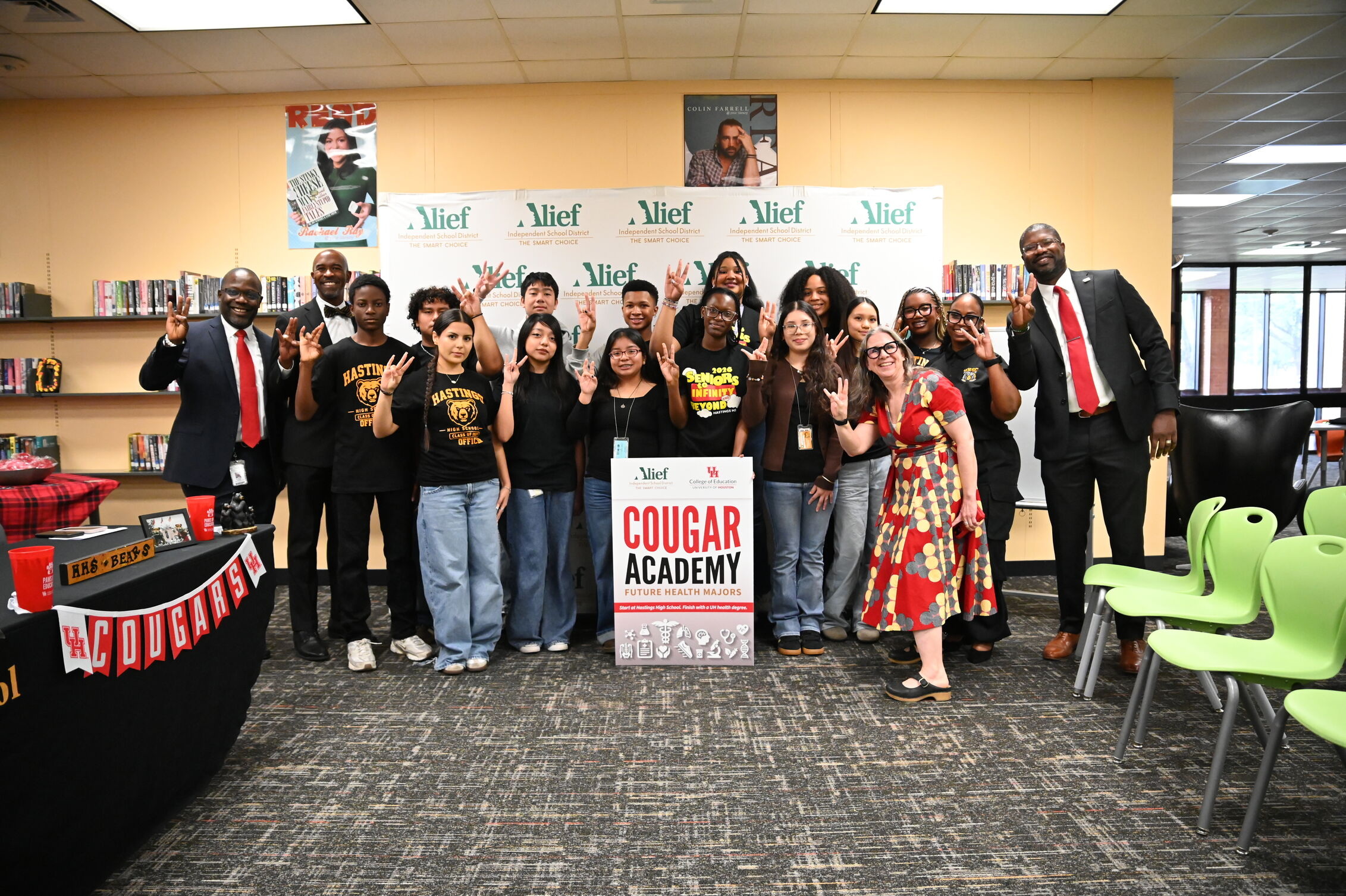 Group of students and school admin doing cougar hand paw sign