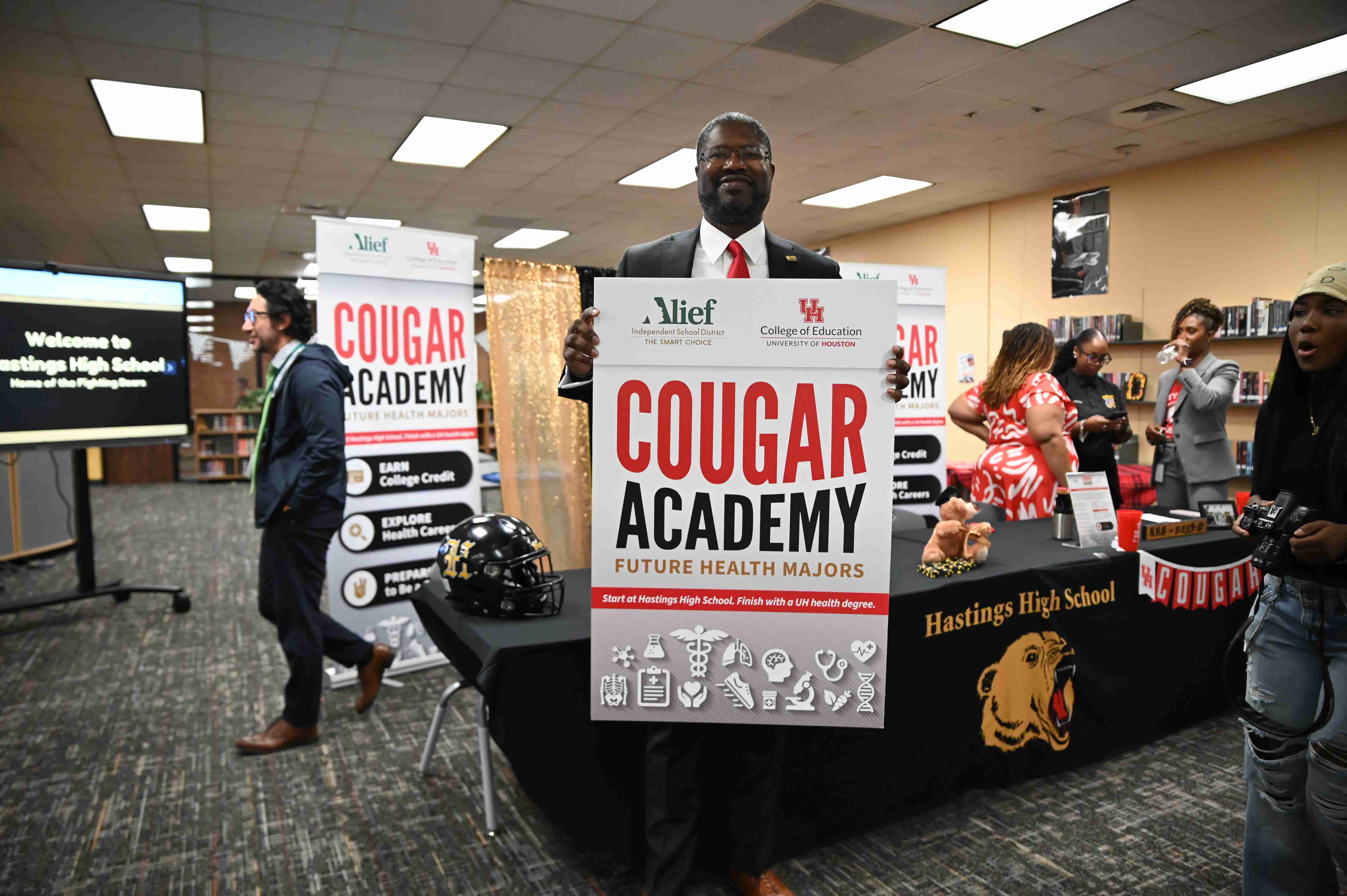 Man Standing with Cougar Academy sign