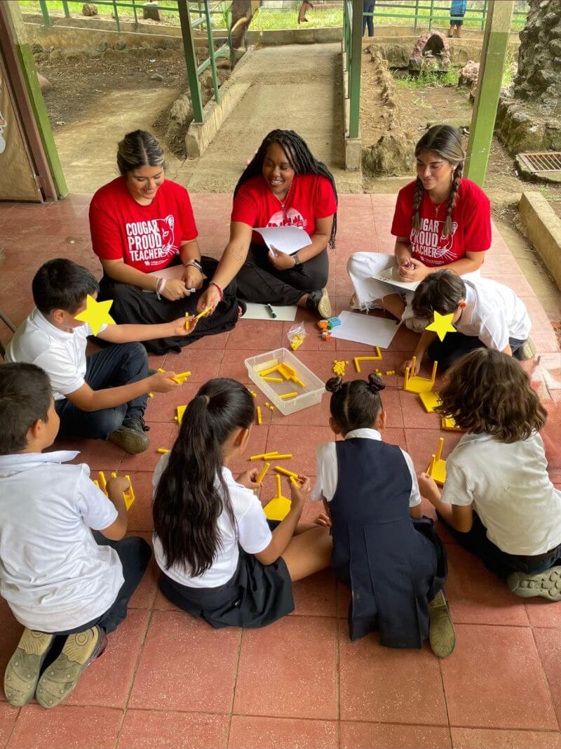 Alyssa Stevenson hands a youth student a math manipulative.