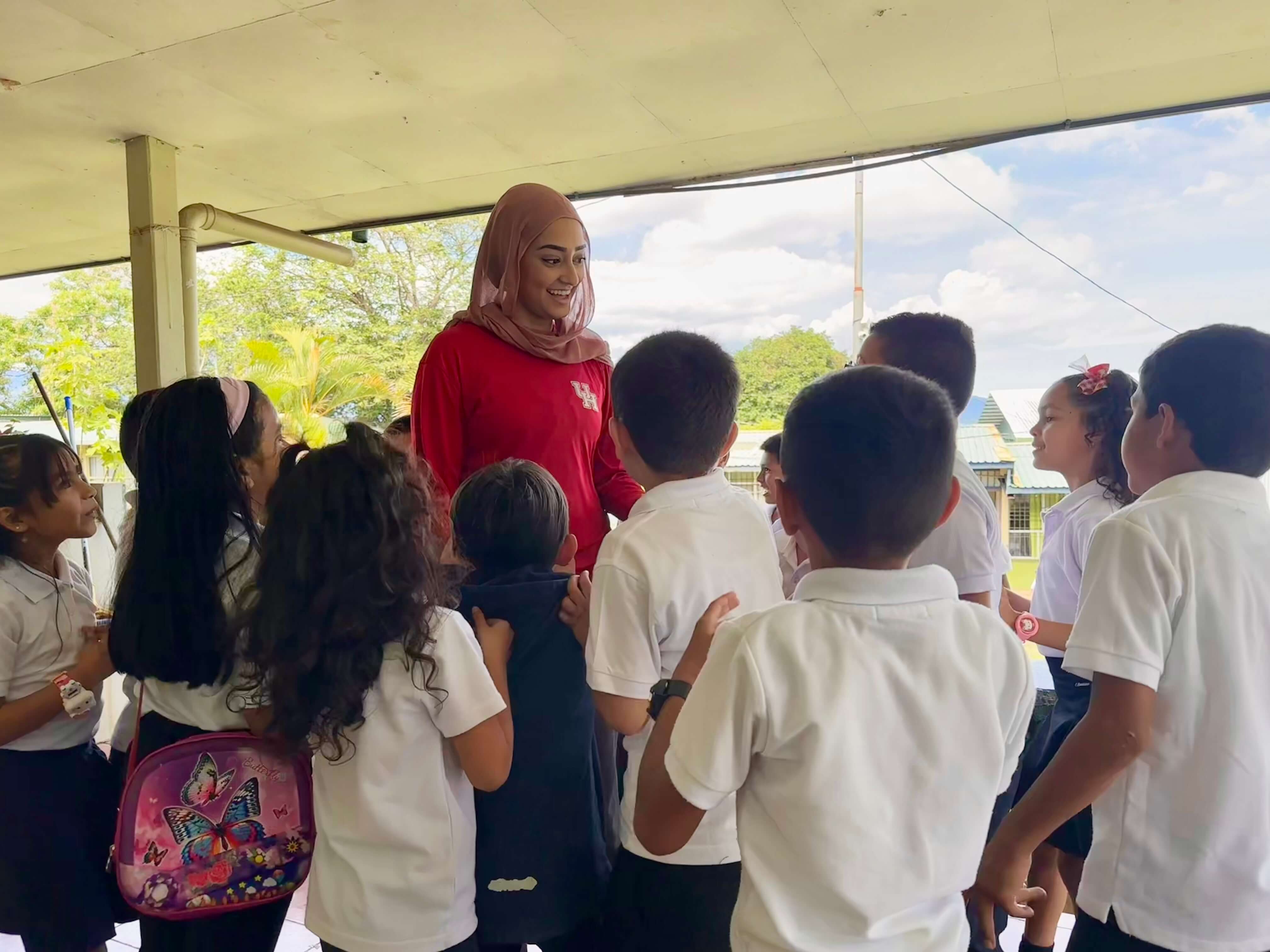 UH student teacher is encircled with young students flocking to her