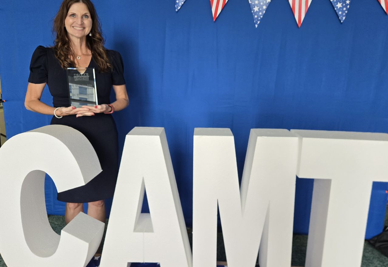 Carrie Culter holds her glass achievement award