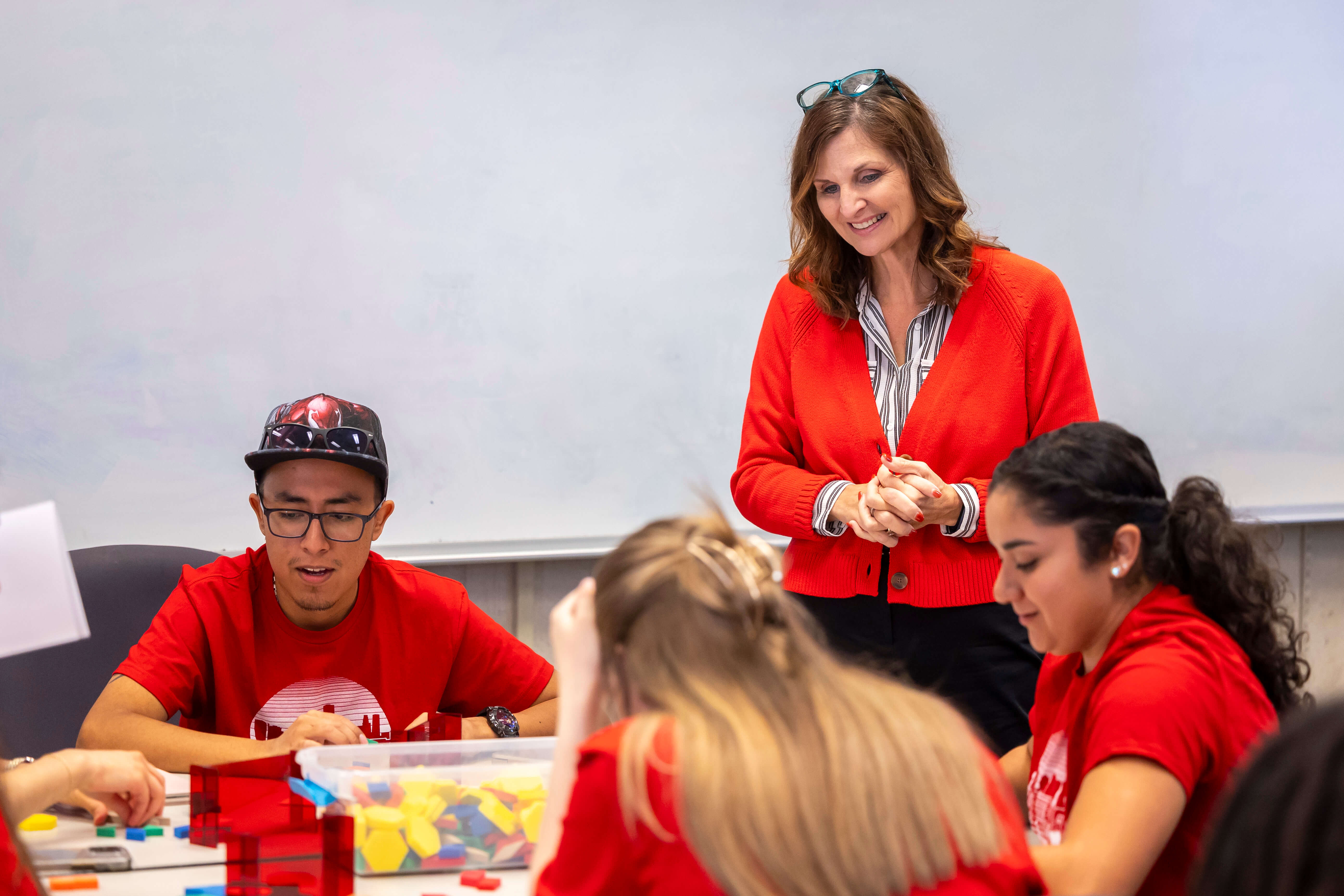 Professor Carrie Cutler observes students in her class working with math manipulatives.