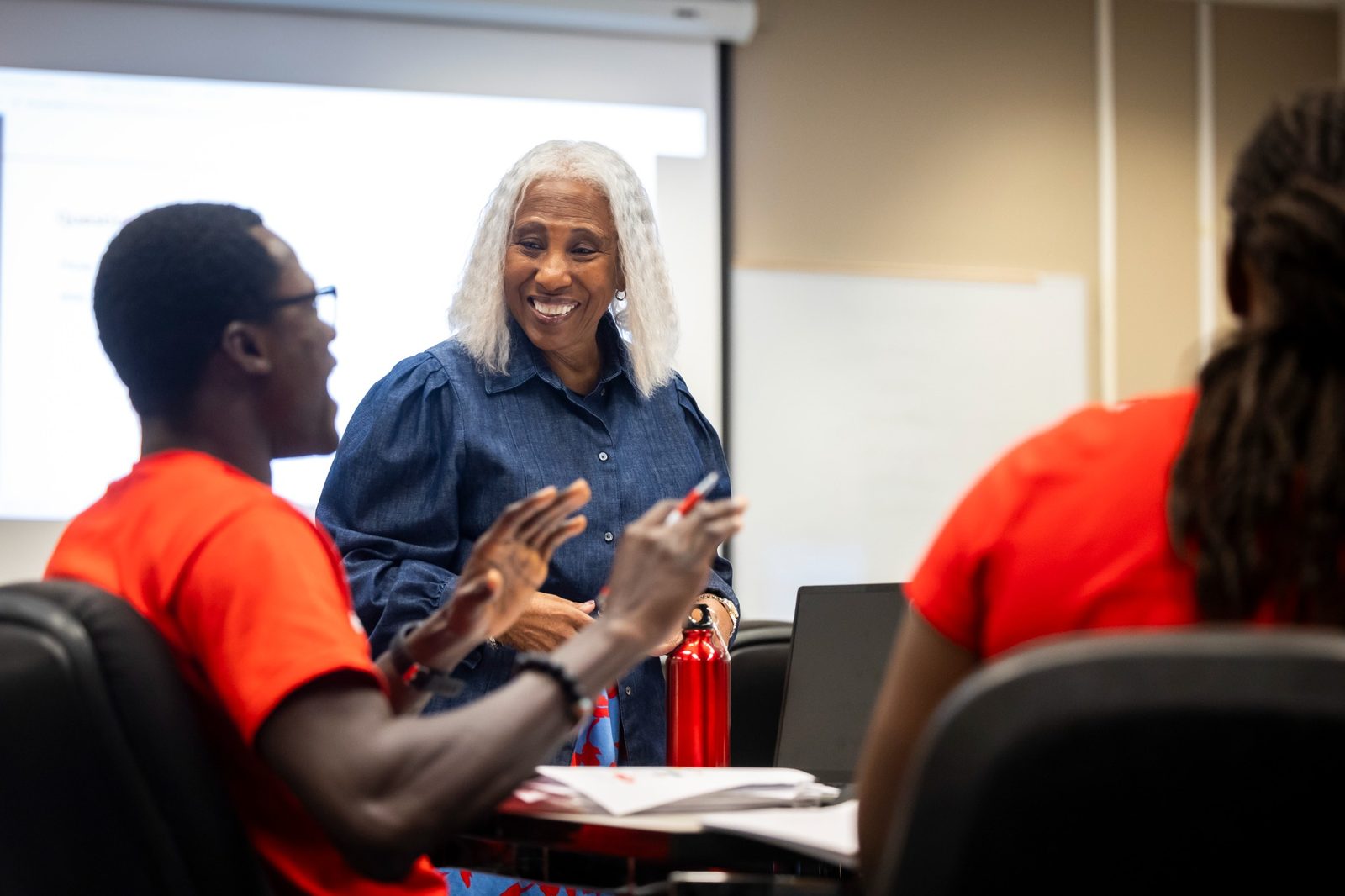 Professor reacts happily to graduate student engaging in class