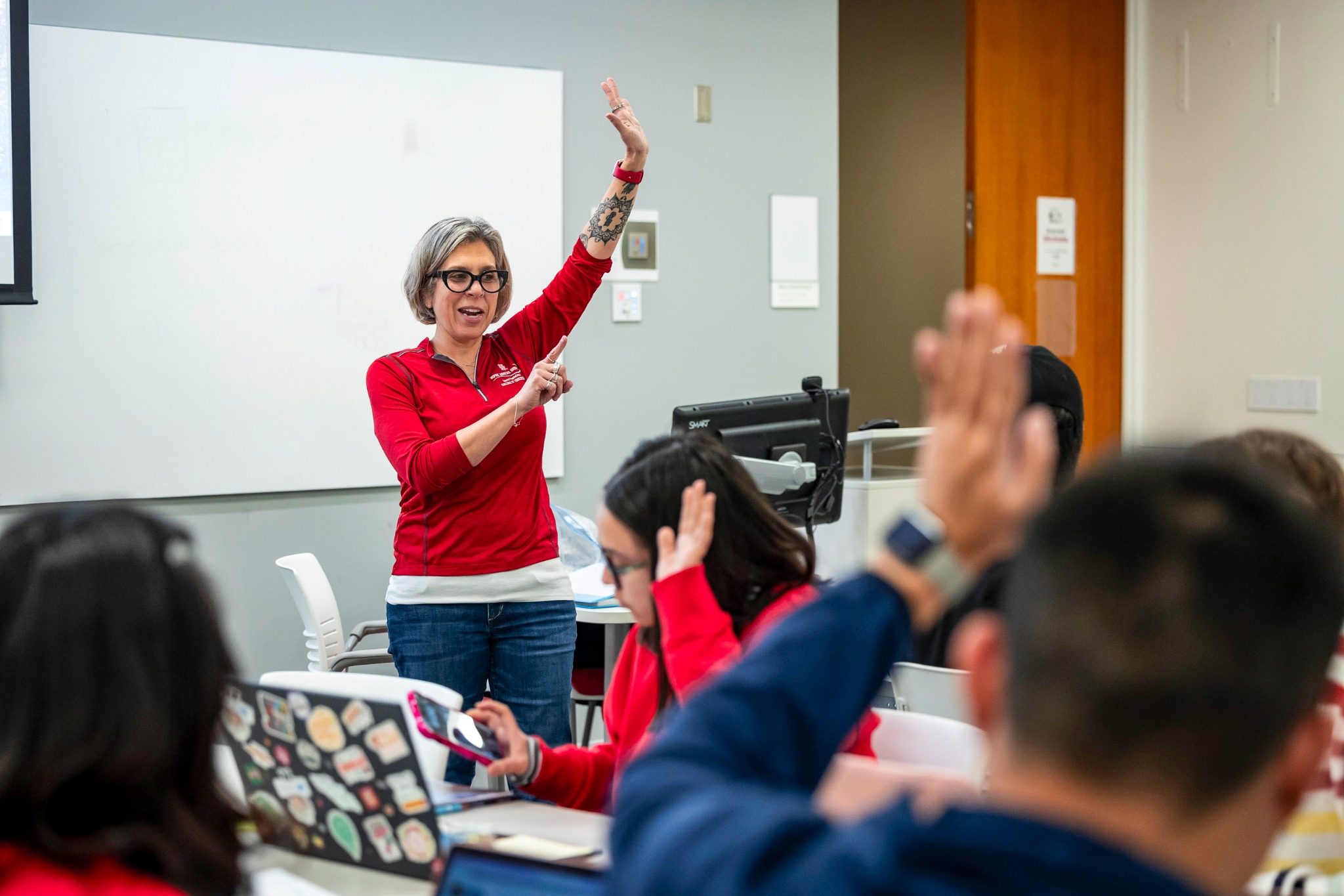 Students in Professor Hope Rigby-Wills' classroom raise their hands, and she does too.