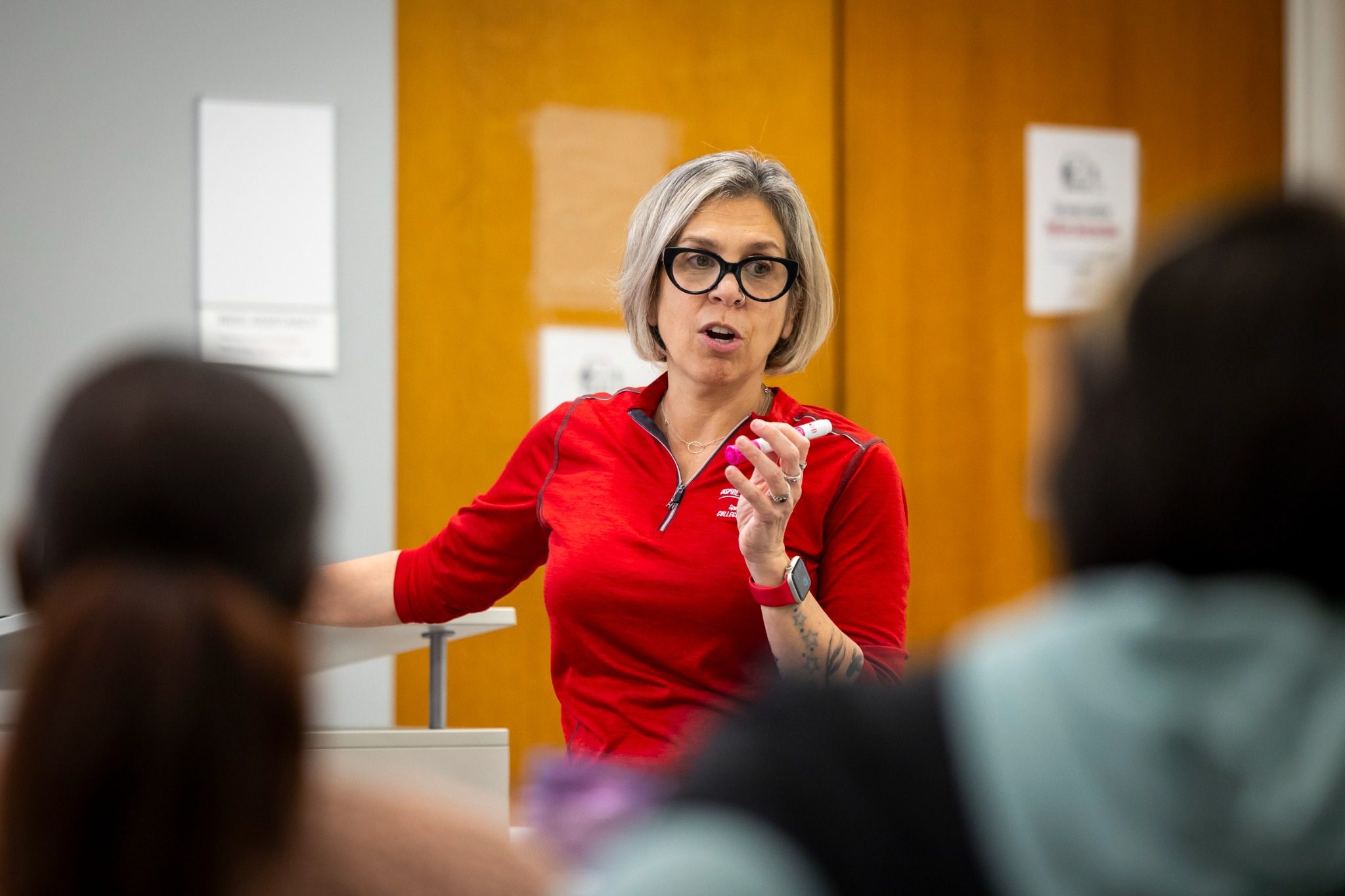 Professor Hope Rigby-Wills gestures to her class with a marker in her hand.
