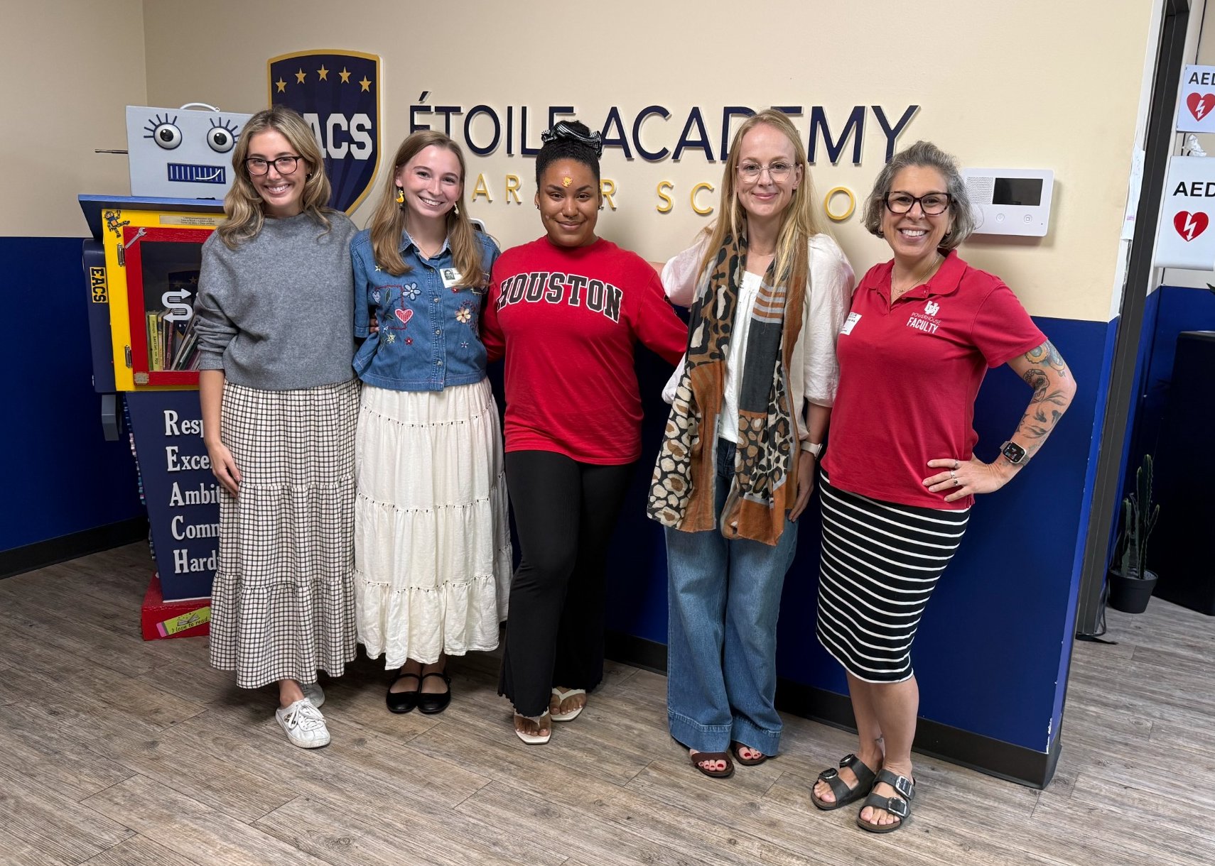 Four UH students or alumni on the SOAR team pose with professor Hope Rigby-Wills instead Etoile Academy.