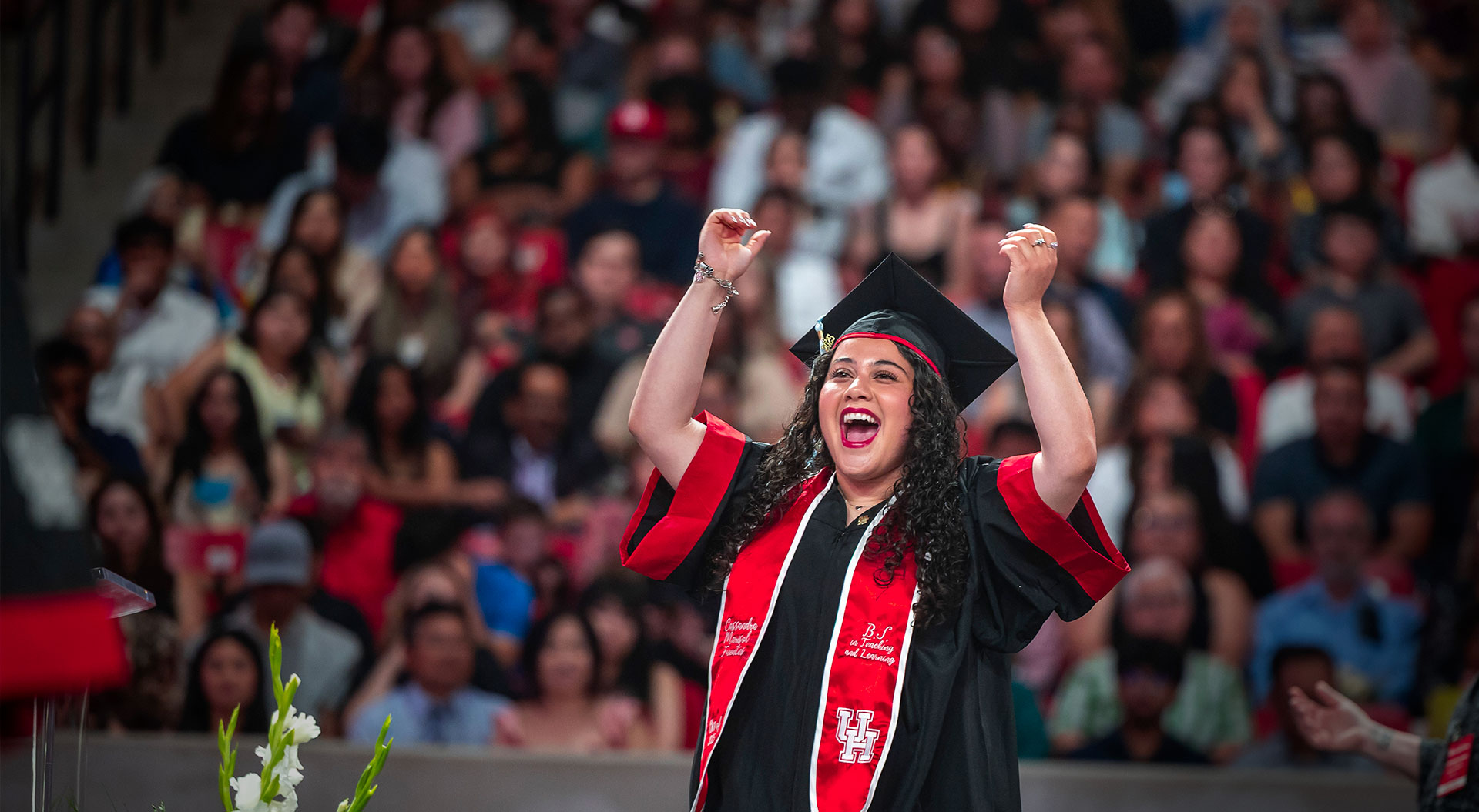 Girl raising her arms with joy at graduation