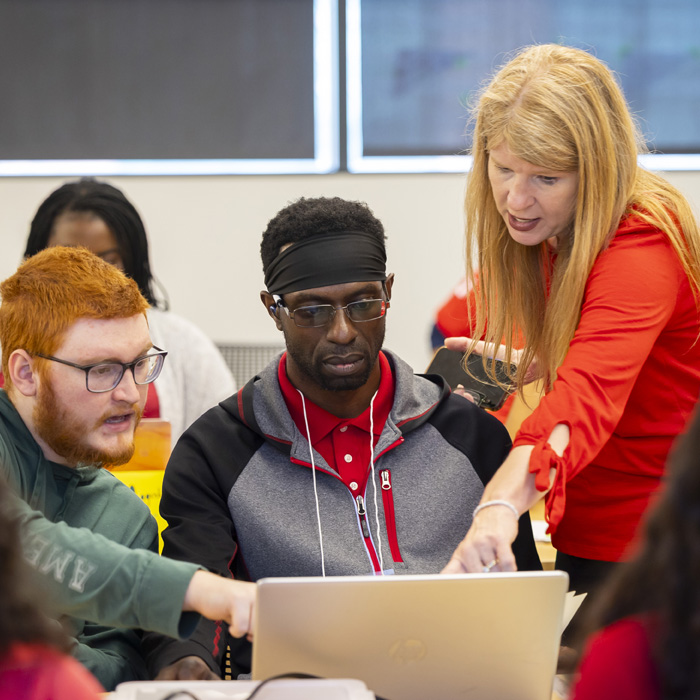 Male student raising his hand in the classroom