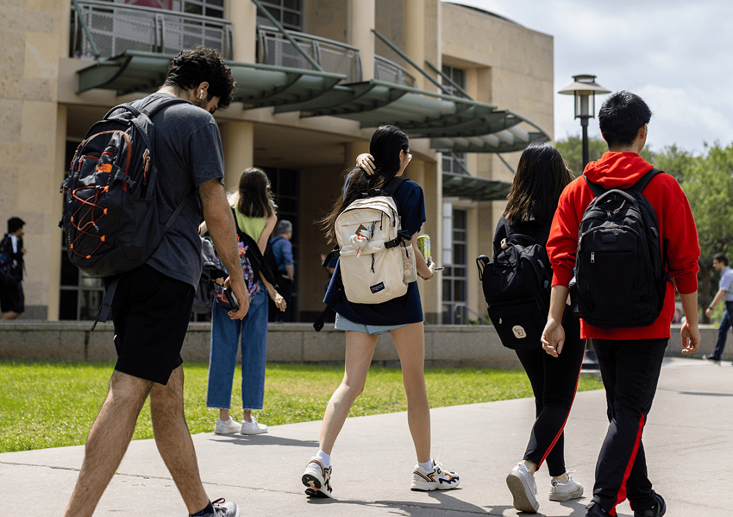 Students walking on campus with backpacks