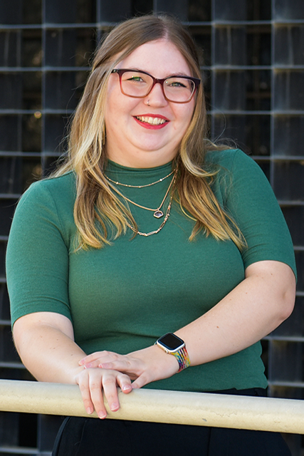Portrait photo of a young white student  leaning on a rail