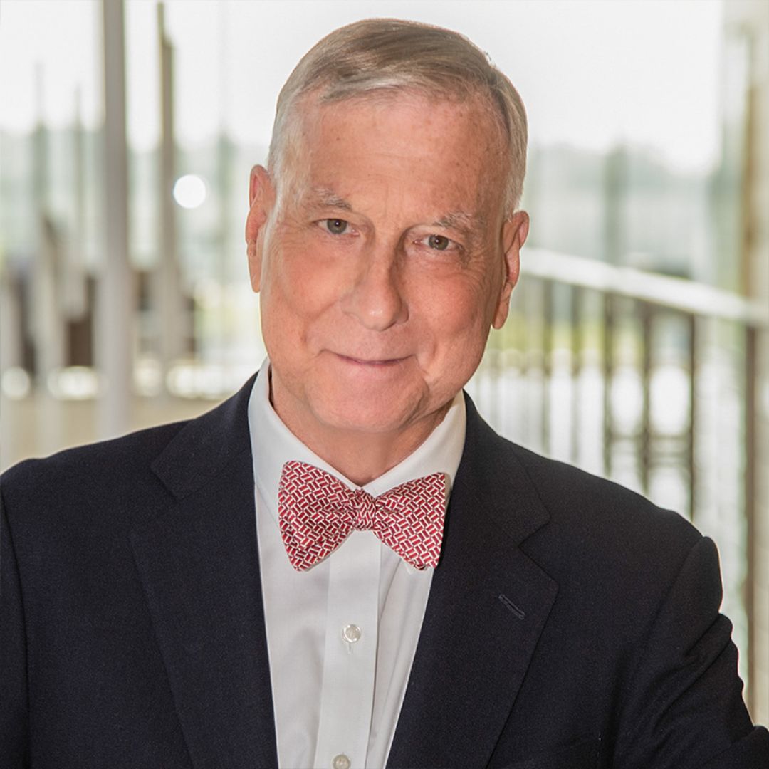 older man with a red bowtie and a dark sports jacket