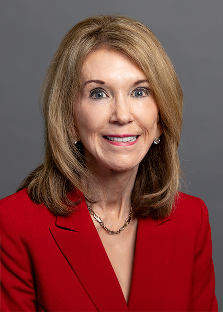 older female with blonde hair in a red suit