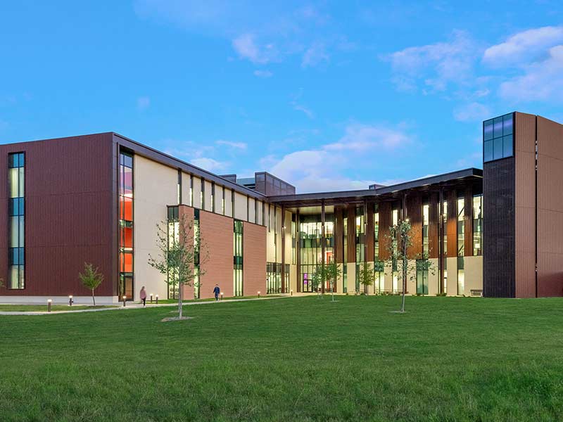 Rear view of the Katy Academic Building with the grass quad flanked by the sides of the building