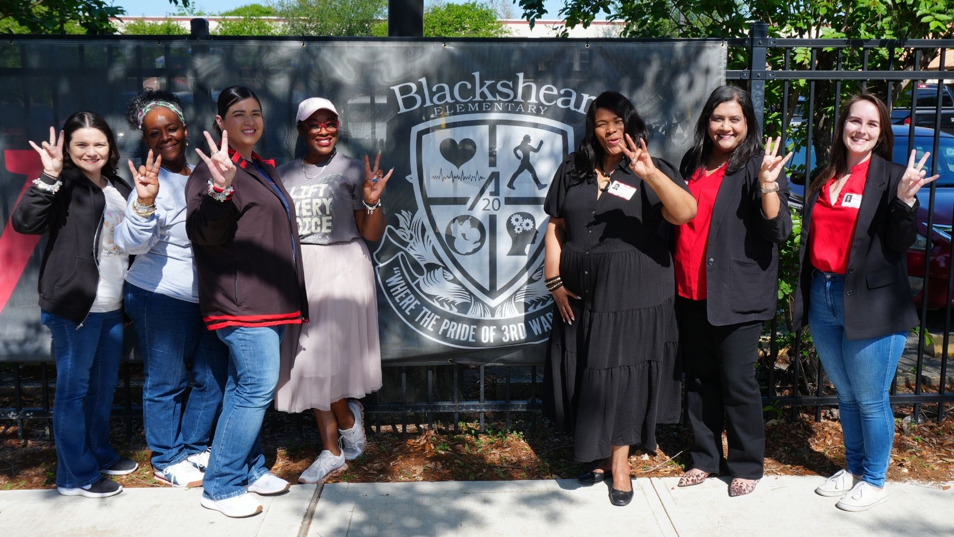 Blackshear and UH stakeholders pose in front of new banner.