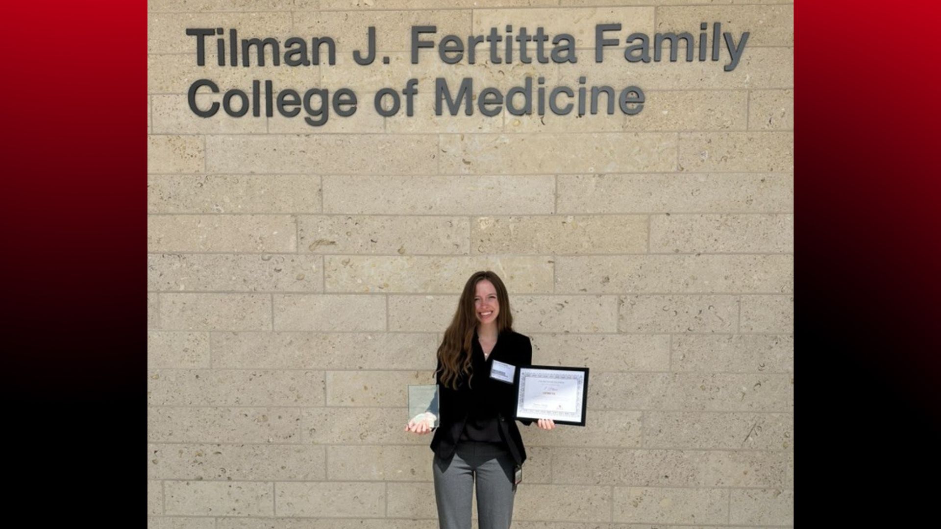 MS2 Hanna Jenkins shows awards outside Tilman J. Fertitta Family College of Medicine
