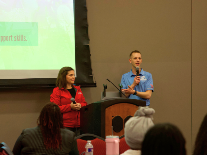 Image of two speakers at the front of the room presenting.