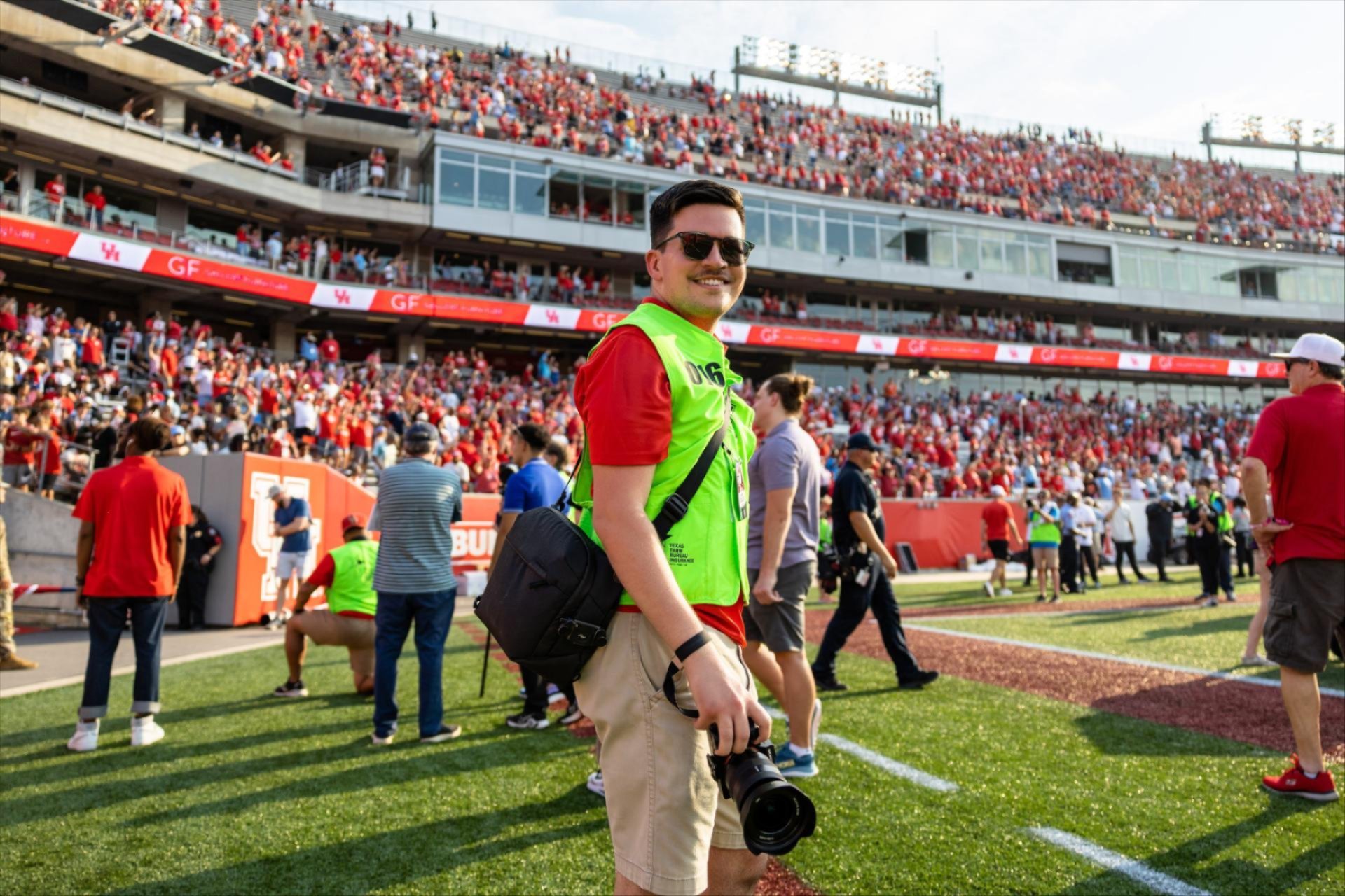 Nick Pomes working the sidelines, capturing the UH Cougar Football team while the crowd brings the energy.