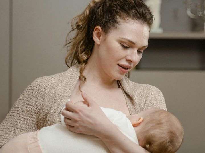 A mother cradles her child to breastfeed the baby.