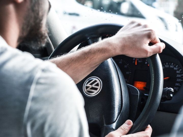 Man clutching car steering wheel small image
