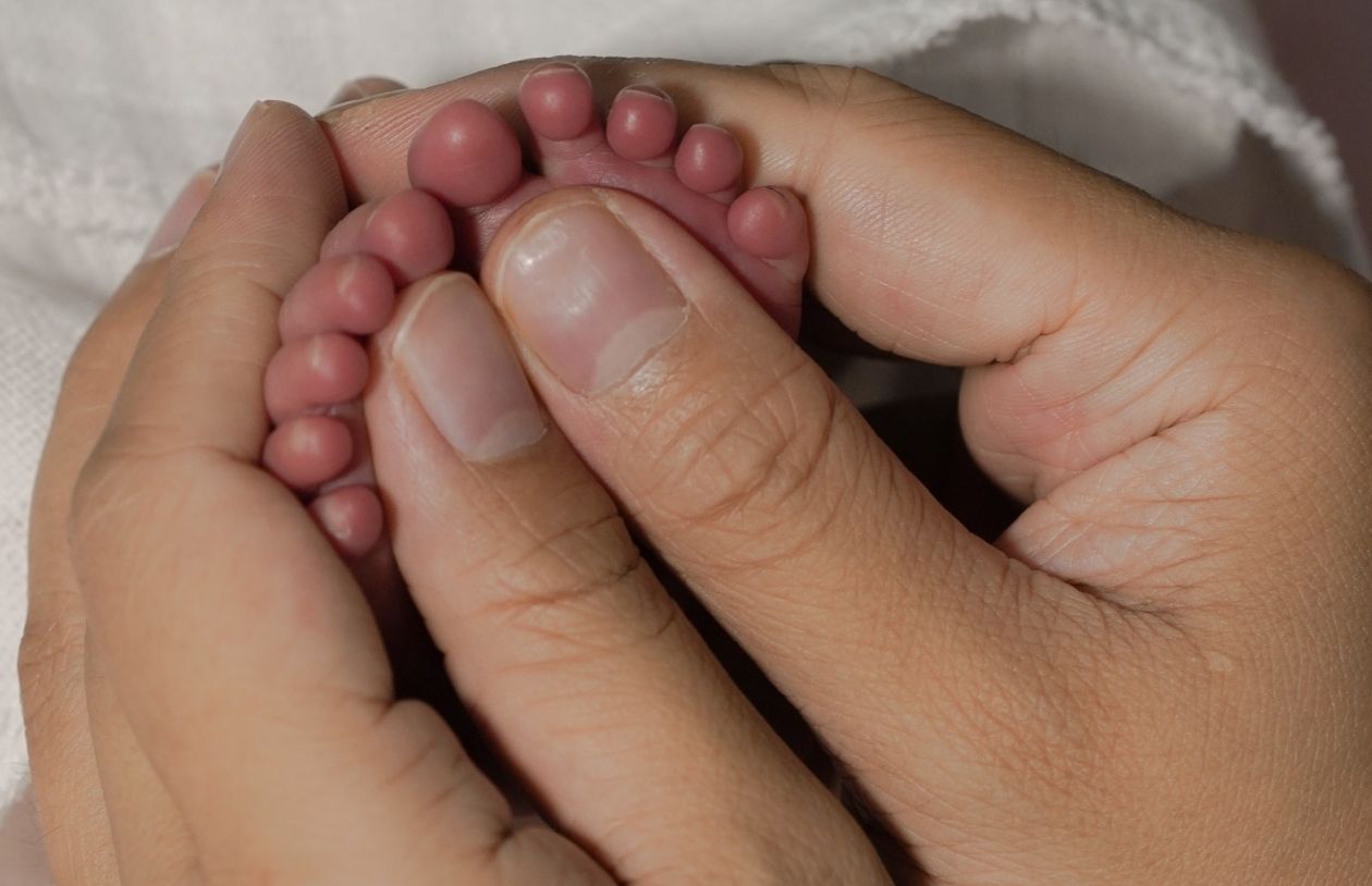 Parent holding feet of premature infant large image