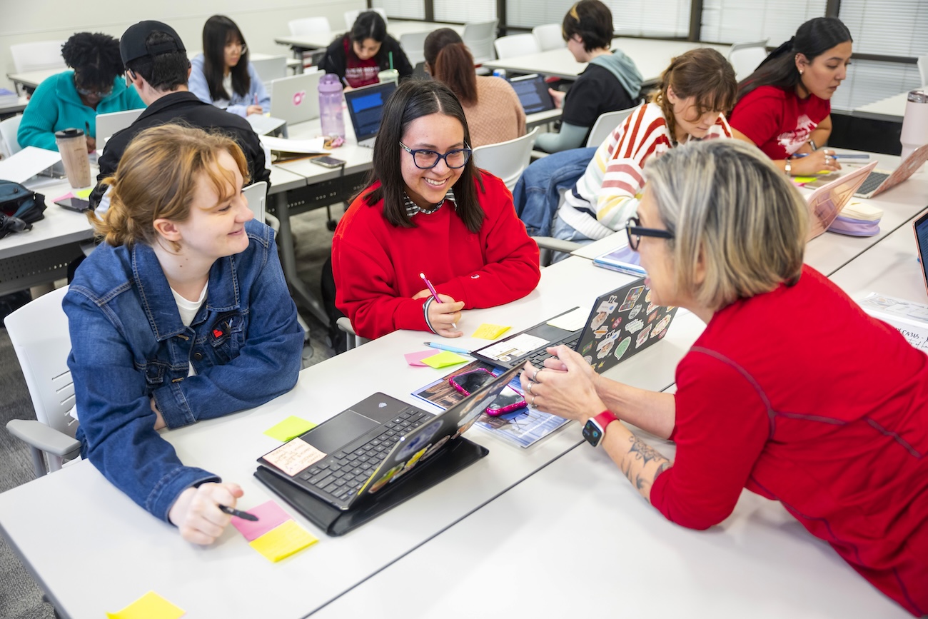 Applied behavior analysis students sit at a desk in class