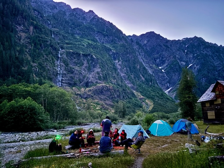 image of students camping under mountains
