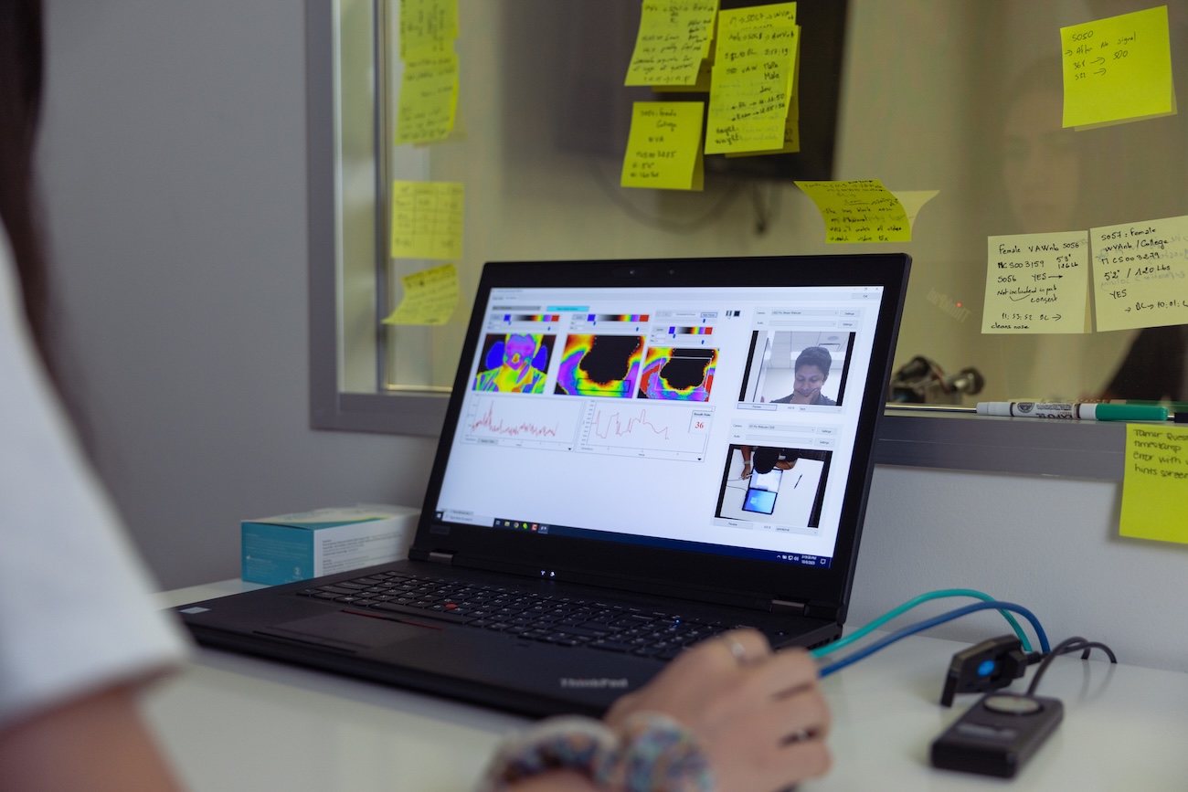 Laptop with thermal imaging and cameras on a student with spontaneous facial self-touching