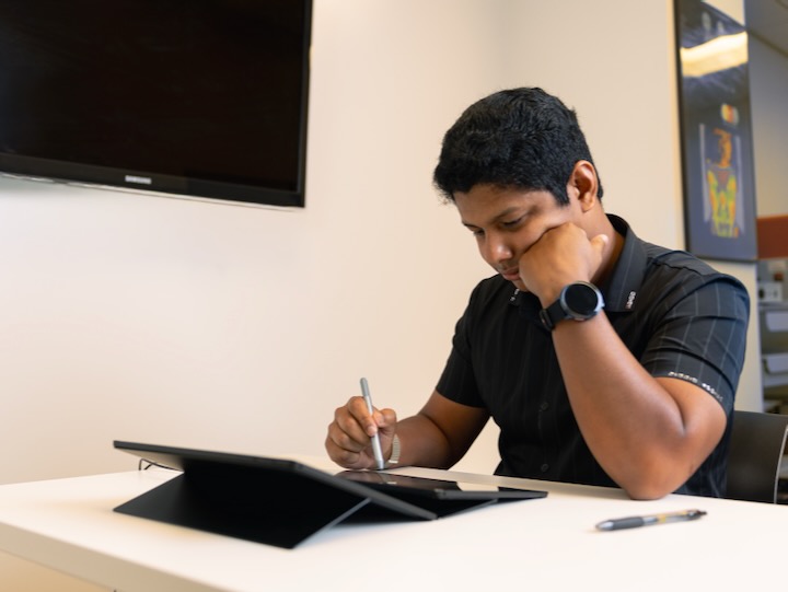 University of Houston student leans on their fist while doing knowledge work