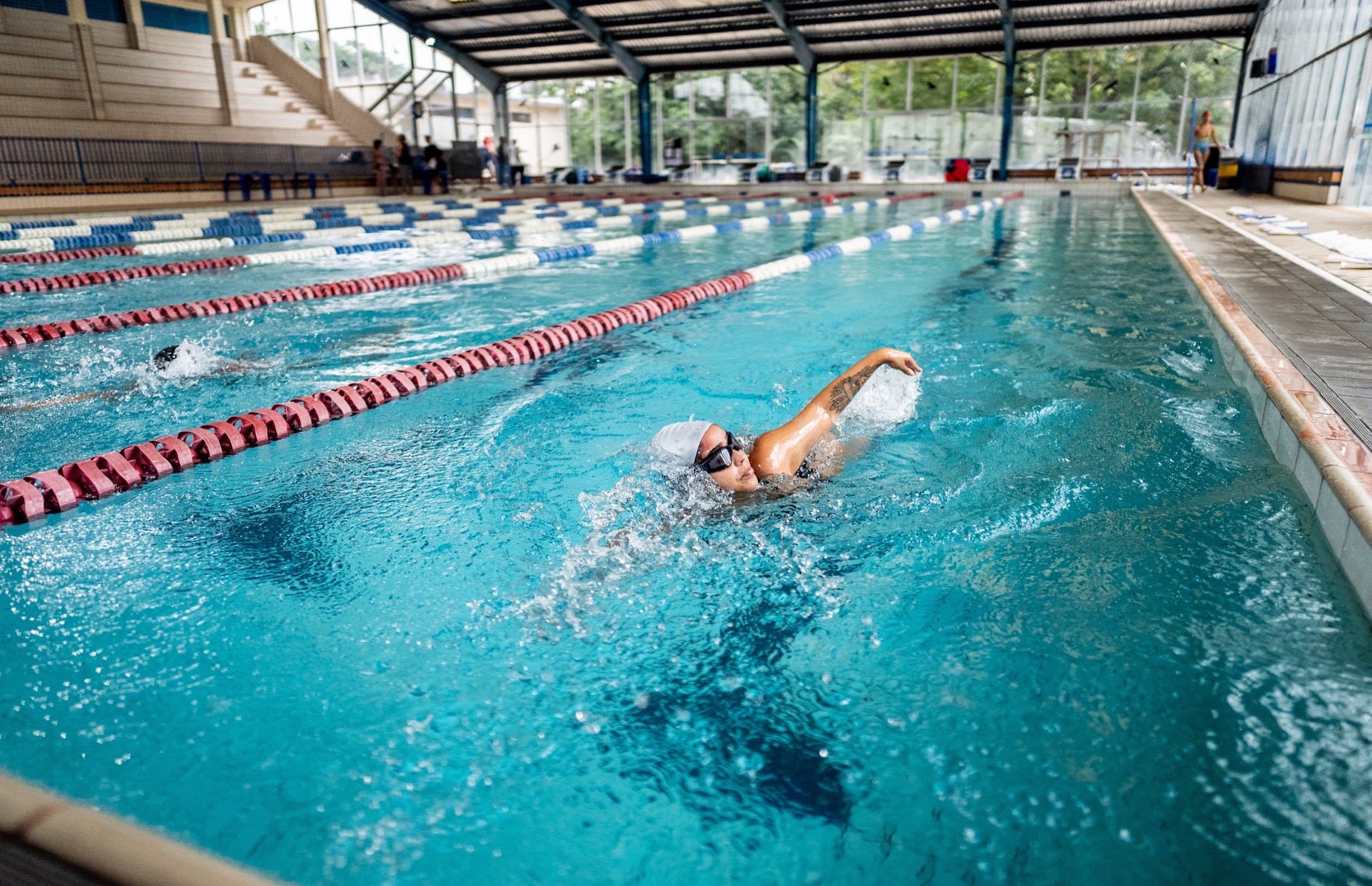 A woman swimming in an indoor pool.