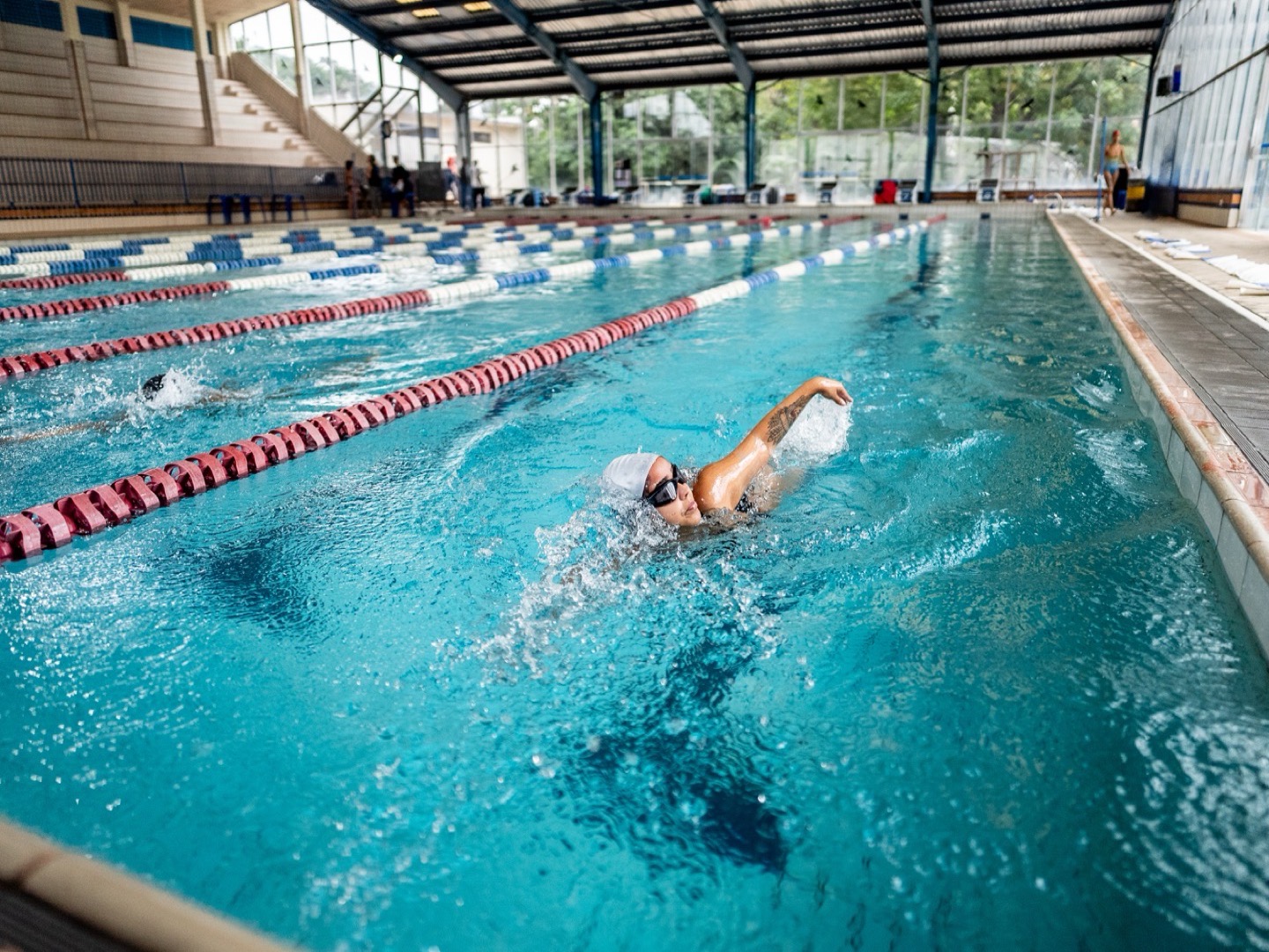 A woman swimming in an indoor pool.