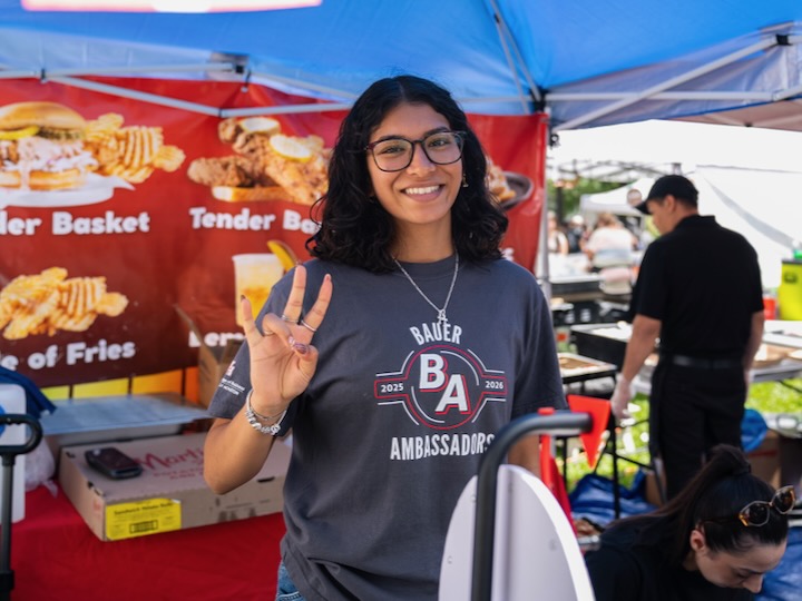 university of houston bauer student gives the cougar hand sign at wolffest