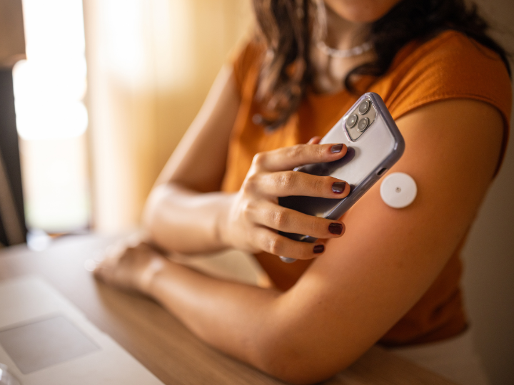 woman checking continuous glucose monitor