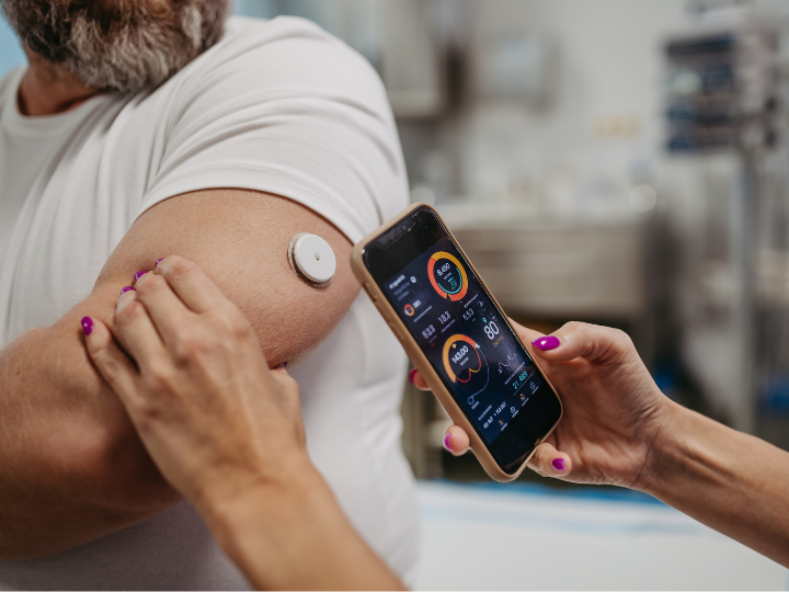 man checking continuous glucose monitor