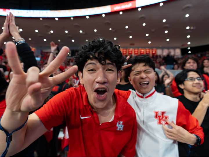 uh students cheering with cougar hand sign