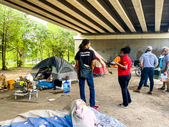 people doing outreach in homeless camp in houston