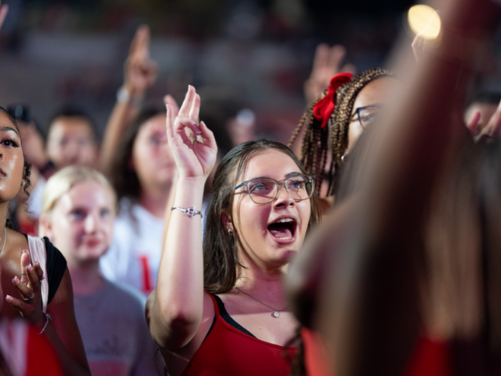student showing cougar sign