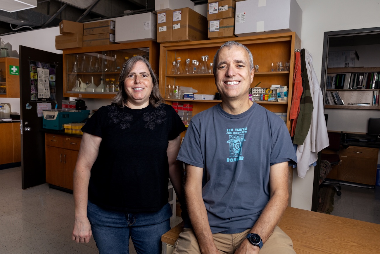 rebecca zufall and ricardo azevedo smile together in a uh lab