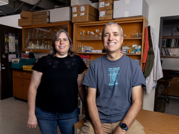 rebecca zufall and ricardo azevedo smile together in a uh lab