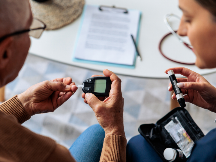home nurse helping a patient check glucose levels