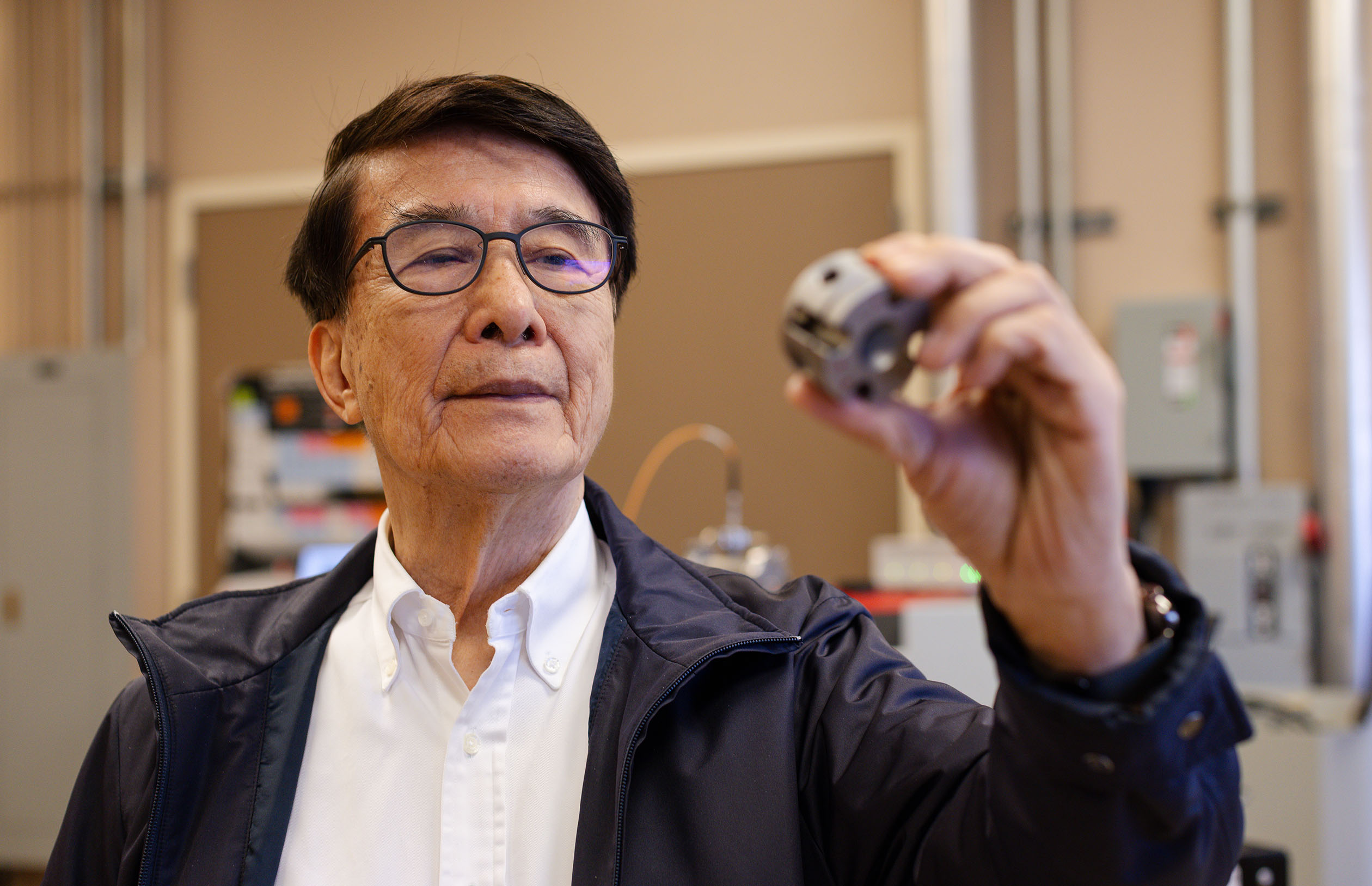 Ching-wu Chu looks at a superconductivity material in the lab.