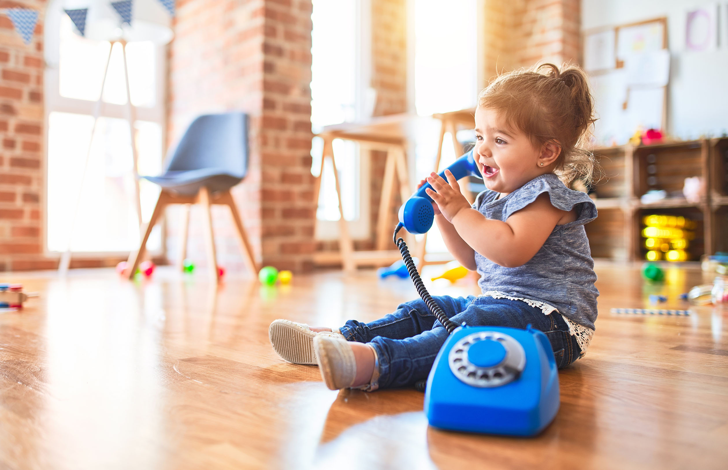Toddler talking on a toy phone.